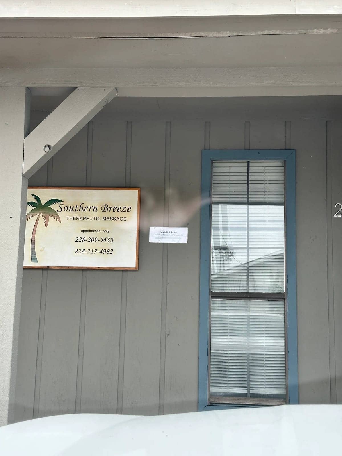 The office entrance at 2206 Old Mobile Avenue in Pascagoula, with a sign for Michelle L. Dixon, Licensed Professional Counselor, next to the Southern Breeze Therapeutic Massage sign