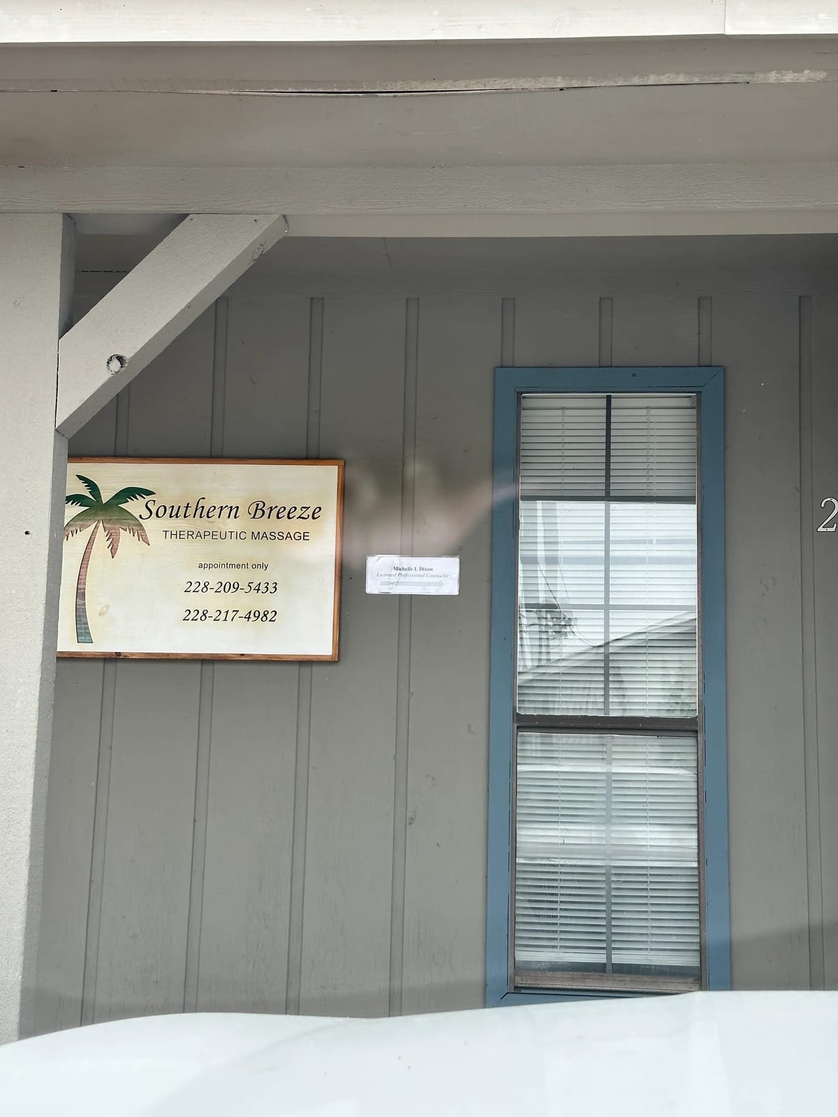 The office entrance at 2206 Old Mobile Avenue in Pascagoula, with a sign for Michelle L. Dixon, Licensed Professional Counselor, next to the Southern Breeze Therapeutic Massage sign